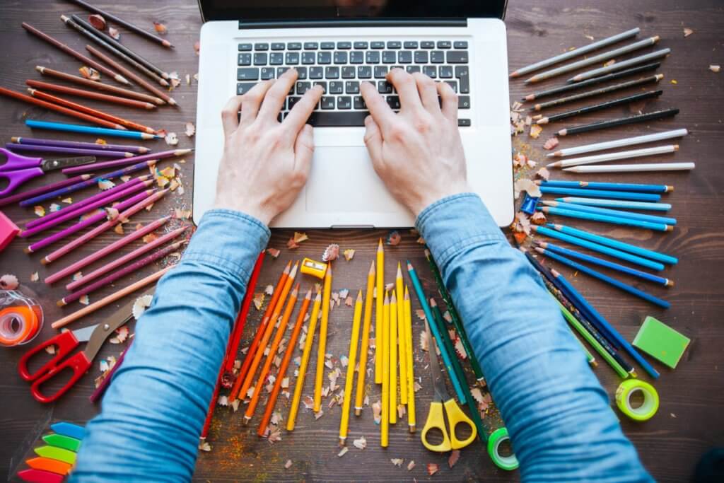 Laptop surrounded by colored pencils