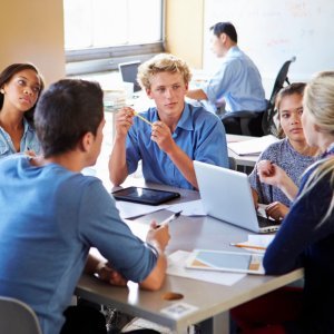 Group of teens in coding class communicating