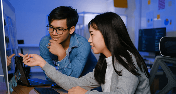 Teen boy and girl in coding class.